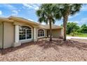 Home exterior with large arched windows providing ample natural light and complemented by the mature palm trees at 2063 E Prairie Cir, Deltona, FL 32725