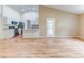 Spacious open floorplan with wood flooring, connecting living and kitchen spaces, with vaulted ceilings at 2063 E Prairie Cir, Deltona, FL 32725