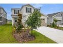 Attractive two-story home with a two-car garage and freshly planted trees at 208 Flag Lilly Ln, Umatilla, FL 32784