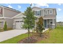 Charming two-story home with gray siding, stone accents, and well-maintained landscaping at 212 Flag Lilly Ln, Umatilla, FL 32784