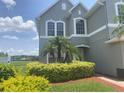 Two-story house with lake view and lush landscaping in the front at 2255 Stone Lake Ct, Orlando, FL 32824