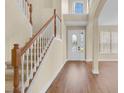 Bright foyer with hardwood floors, a staircase with white railings, and a decorative glass front door at 2255 Stone Lake Ct, Orlando, FL 32824