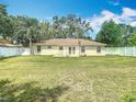 Spacious backyard featuring a lush lawn, white fencing, and a charming patio area for outdoor enjoyment at 2493 Pine Chase Cir, St Cloud, FL 34769