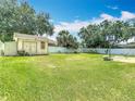 Large backyard with a storage shed, open grassy area, and a basketball hoop, perfect for recreation at 2493 Pine Chase Cir, St Cloud, FL 34769