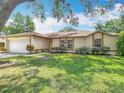 Inviting single-story home with a two-car garage, lush green lawn, and attractive landscaping at 2493 Pine Chase Cir, St Cloud, FL 34769