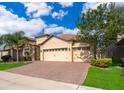 Inviting single-story home with a brick driveway, a well-kept lawn, and mature tree at 2736 Atherton Dr, Orlando, FL 32824