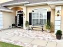 Inviting front entrance with stylish door, decorative plants, seating, and brick-paved landing at 3 Sunrise Dr, Ocala, FL 34472