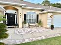 Close-up of the front door and welcoming tiled entrance, complemented by decorative plants and a bench at 3 Sunrise Dr, Ocala, FL 34472