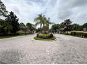 Community entrance featuring a palm tree lined roundabout with lush landscaping at 3664 Wilshire Way Rd # 261, Orlando, FL 32829