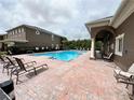 Community pool area with lounge chairs and covered seating area for relaxation at 3664 Wilshire Way Rd # 261, Orlando, FL 32829