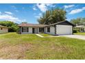 Single-Gathering home with black and white accent and an attached two-car garage at 406 Long Dr, Kissimmee, FL 34759