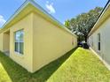 The side of the home includes a well kept lawn, AC unit and a view of the neighboring property at 4307 Creeks Run Blvd, Kissimmee, FL 34746