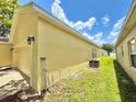 The side of the house includes a well kept lawn, AC unit and a view of the neighboring property at 4307 Creeks Run Blvd, Kissimmee, FL 34746
