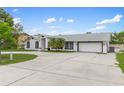 Single-story home featuring a teal front door, attached garage, and wide driveway at 4407 Lake Trudy Dr, St Cloud, FL 34769