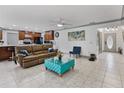 Spacious living room with tile floors, a ceiling fan, and an open floor plan to the kitchen at 4407 Lake Trudy Dr, St Cloud, FL 34769