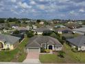 Expansive view of the neighborhood showcasing a single-story home, mature trees, and green lawns at 458 Moscato Dr, Davenport, FL 33897