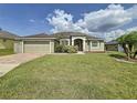 Single story home with landscaped front yard, brick driveway, and neutral color scheme at 458 Moscato Dr, Davenport, FL 33897