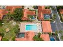 Aerial view of homes with terracotta roofs, a community pool, and tropical landscaping at 5015 Nassau Cir # 4, Orlando, FL 32808