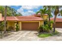 Charming single-story home with a terracotta roof, lush landscaping, and a two-car garage at 5015 Nassau Cir # 4, Orlando, FL 32808