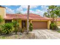 Charming single-story home with a terracotta roof, lush landscaping, and a two-car garage at 5015 Nassau Cir # 4, Orlando, FL 32808