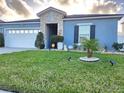 Attractive single-story home with a well-kept lawn, landscape lighting, and stone accents at 585 Lucerne Blvd, Winter Haven, FL 33881
