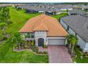 Aerial view of home showing meticulous landscaping, paved driveway, and tile roof at 605 San Augusto Dr, Kissimmee, FL 34759