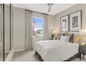 Comfortable bedroom with neutral decor, a large window with patterned curtains, and plush carpeting at 6167 Daphne St, Lake Hamilton, FL 33851