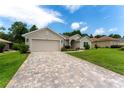 Single-story home with a two-car garage, brick driveway and well-maintained lawn at 6644 Sw 179Th Court Rd, Dunnellon, FL 34432