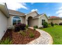 Close-up of a home's entrance featuring a decorative walkway and mature landscaping at 6644 Sw 179Th Court Rd, Dunnellon, FL 34432