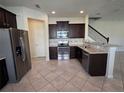 Open kitchen featuring stainless steel appliances and dark cabinetry at 1069 Pavia Dr, Apopka, FL 32703