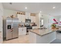 Bright kitchen showcasing white cabinets, stainless steel appliances, and a granite-topped island with a double sink at 1102 Tupelo Trl, Haines City, FL 33844