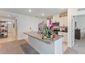 Kitchen island featuring granite countertops, stainless steel appliances, and ample storage for modern convenience at 1102 Tupelo Trl, Haines City, FL 33844