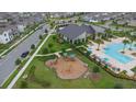 Community aerial view with pool, playground, clubhouse, and manicured landscaping showcases wonderful neighborhood at 11328 Listening Dr, Orlando, FL 32832