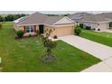 Inviting single-story home with red shutters, a manicured lawn, and solar panels for energy efficiency at 1158 Legatto Loop, Dundee, FL 33838