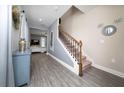 Inviting entryway with wood-look floors, decorative stair railing, and a view into the living space at 1335 Greenfield Loop, Kissimmee, FL 34747