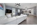 Open-concept living room with modern decor, and seamless flow to the adjacent kitchen at 1335 Greenfield Loop, Kissimmee, FL 34747
