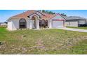Charming single-story home featuring a symmetrical facade, arched windows, and a well-manicured lawn at 1912 Manatee Ln, Poinciana, FL 34759