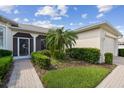 Inviting front entrance with a screened door, lush garden, and paved walkway at 201 Largo Dr, Kissimmee, FL 34759