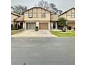 Two-story tan home with brown trim, attached garage, and well-manicured front lawn at 2031 Balboa Way, Kissimmee, FL 34741