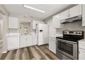 Well-lit kitchen boasts white cabinets, stainless steel appliances, and modern countertops at 2146 Fish Eagle St, Clermont, FL 34714