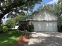 Single-story home boasts an attached two-car garage, landscaped yard, and charming curb appeal at 2225 Maryday Ct, Orlando, FL 32812