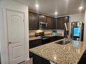 Modern kitchen featuring granite countertops, stainless steel appliances, ample cabinet space and a large kitchen island at 2309 Rio Grande Forest Ln, Kissimmee, FL 34759