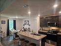 Open concept kitchen with granite countertops, dark wood cabinetry, stainless steel appliances, and an island with seating at 2309 Rio Grande Forest Ln, Kissimmee, FL 34759