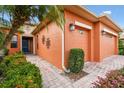 Close up of the charming home with brick walkway, colorful flowers, and a blue front door at 271 Indian Wells Ave, Poinciana, FL 34759