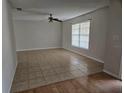 Open living room with tile flooring, a ceiling fan, and a large window for natural light at 2805 Rodeo Dr, Kissimmee, FL 34746