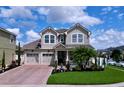 Charming two-story home with a well-manicured lawn, brick driveway, and a welcoming front porch at 2939 Sera Bella Way, Kissimmee, FL 34744