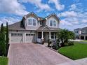 Charming two-story home with a well-manicured lawn, brick driveway, and a welcoming front porch at 2939 Sera Bella Way, Kissimmee, FL 34744