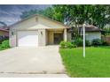 Charming single-story home with a brick facade, attached garage, and a well-maintained lawn at 3 Rosewood Dr, Davenport, FL 33837