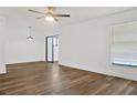 Bright living room featuring new wood floors, ceiling fan, and large window with a view at 3 Rosewood Dr, Davenport, FL 33837