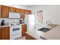 Efficient kitchen featuring white appliances and wood cabinets, ideal for cooking and storage at 4014 Santa Maria Dr # 101, Kissimmee, FL 34741
